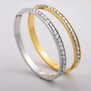 Detailed macro view of gold and silver bangles with rectangular cubic zirconia inlay