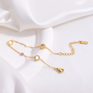 Detailed macro of a gold-plated stainless steel bracelet with a Roman numeral crystal charm