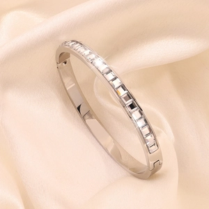Close-up of silver stainless steel bangle with square-cut cubic zirconia on silk