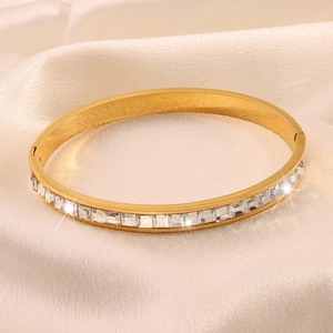 Detailed close-up of a gold-plated bangle with square-cut cubic zirconia in a bezel setting