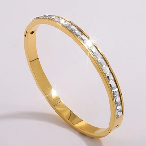 Detailed view of gold plated bangle with sparkling channel-set rectangular zircon stones