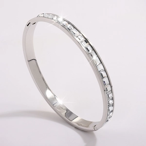 Macro shot of polished silver bangle with cubic zirconia square settings and hinge detail