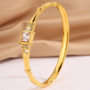 Detail of gold-plated bangle featuring a square-cut gemstone and micro-pave setting