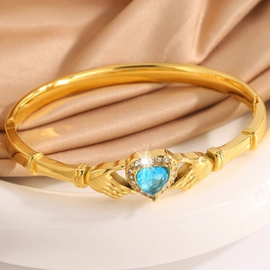 Macro shot of Claddagh heart-shaped blue gem bracelet with diamonds and gold plating