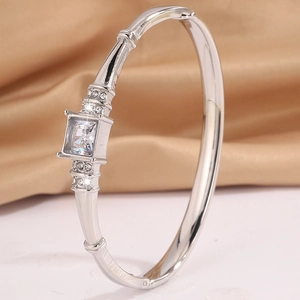 Macro shot of silver bangle featuring a square-cut center stone and sparkling side accents