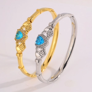 Detail of Claddagh style heart bracelets with blue gemstone and zircon inlay