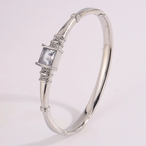 Detail view of silver stainless steel bangle featuring a square-cut central zircon stone