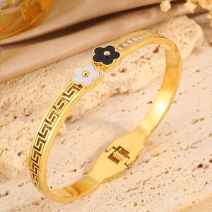 Detail of gold-plated stainless steel bracelet with Greek key pattern and floral zircon