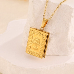 Makro-Detail des goldenen Buch-Medaillons mit Lebensbaum-Relief und griechischem Muster
