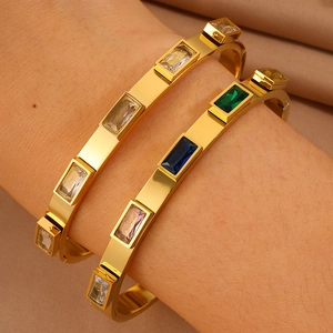 Primo piano di bracciali in acciaio inossidabile placcati oro 18K con pietre colorate