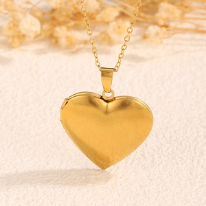 Makroaufnahme des goldenen herzförmigen Medaillons mit glatter Oberfläche und Scharnier
