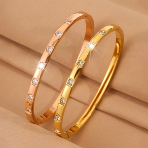 Minimalist titanium steel bangles in gold and rose gold with seven inset zircons