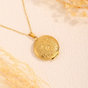 Nahaufnahme eines goldenen runden Medaillons mit feinem Blumenrelief im Vintage-Stil