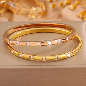 Detail of rose gold and gold titanium steel bracelets with cubic zirconia inlays