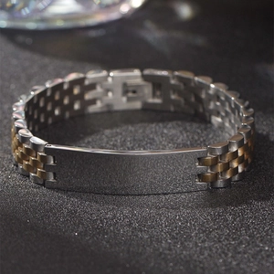 Macro detail of stainless steel watch band bracelet with two-tone finish and engravable plate