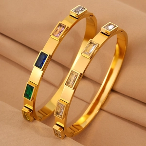 Due bracciali rigidi in acciaio dorato 18K con gemme rettangolari multicolori