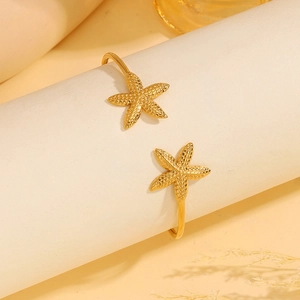 Detailopname van gouden roestvrijstalen zeester armband op een beige standaard