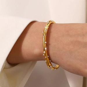 Gepolijste gouden roestvrijstalen armband met onregelmatige textuur en parels