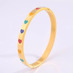 Detail of 18k gold plated stainless steel bangle with colorful enamel heart patterns