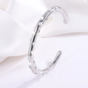 Detail van zilveren roestvrijstalen armband met witte parels en glinsterende kristallen