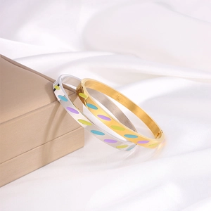 Détail de joncs plaqués or 18 carats et argent avec motifs en émail coloré sur velours