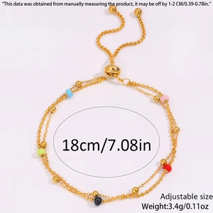 Detail view of golden dual-chain bracelet with colorful beads and adjustable slide clasp
