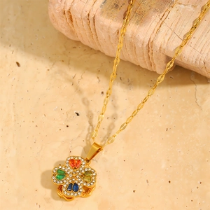 Detail of clover pendant with colorful gems and sparkling crystals on gold chain