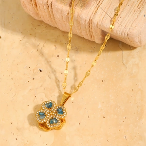 Macro detail of rotating four-leaf clover necklace with blue inlay and crystals
