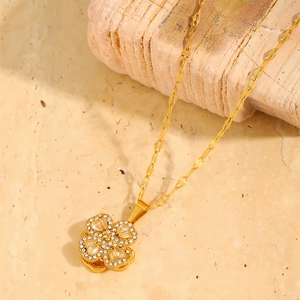 Detail of a rotating clover necklace in 18k gold plating with sparkling rhinestones