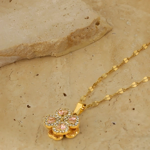 Detailed close-up of rotating four-leaf clover necklace with pink gems and zircons