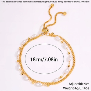 Detail of double-layer stainless steel pearl bracelet with adjustable slider closure and golden finish