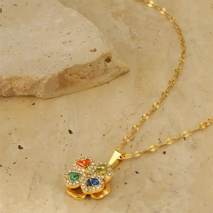 Detail of 18k gold plated rotating clover pendant with multicolor gemstones and crystals
