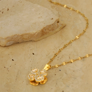 Detailed close-up of 18k gold plated rotating clover necklace with sparkling cubic zirconia
