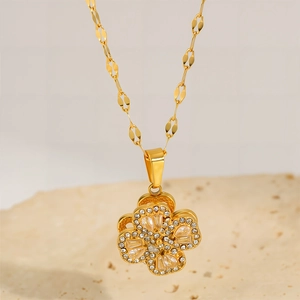 Macro detail of rotating clover pendant necklace with sparkling zircons in gold