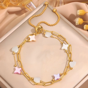 Titanium steel gold bracelet with colorful heart and star charms on a silk background