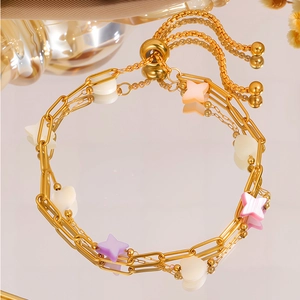 Elegant 18K gold plated titanium bracelet with colorful heart and star charms on mirror