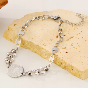 Detailaufnahme des silbernen Sankt-Benedikt-Armbands mit Perlen und Schweinenasen-Kette