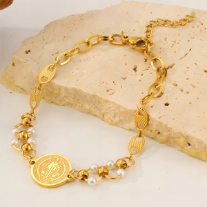 Detail der goldfarbenen Benediktus-Medaille mit weißen Perlen und Gliederkette