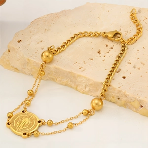 Makroaufnahme von Gold-Edelstahlarmband mit Benediktusmedaille und Panzerketten-Details