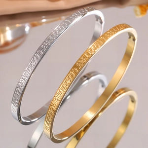 Dettaglio dei bracciali in acciaio al titanio oro e argento con texture martellata