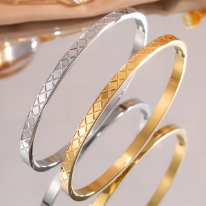 Dettaglio macro del motivo a griglia geometrica su bracciali in acciaio inossidabile