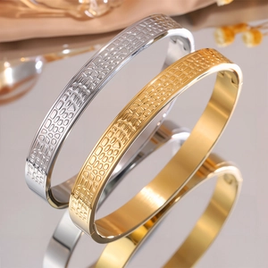 Dettaglio macro di bracciali in acciaio oro e argento con trama coccodrillo a rilievo