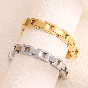 Détail de bracelets à maillons géométriques en acier doré et argenté sur supports blancs