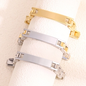 Trois bracelets ID en acier titane or, argent et bicolore présentés sur des supports blancs