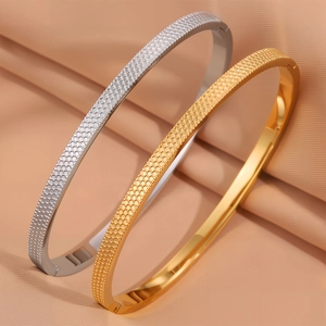 Dettaglio macro di bracciali placcati oro e argento con trama a nido d'ape fine