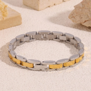 Vue macro d'un bracelet à maillons en acier inoxydable bicolore avec touches or et argent