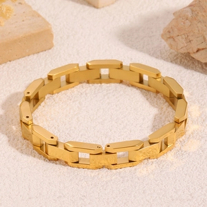 Vue détaillée de la texture en acier brossé doré et des maillons du bracelet moderne