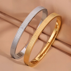 Dettaglio macro di bracciali in titanio con trama a nido d'ape esagonale in oro e argento