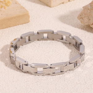 Gros plan d'un bracelet en acier titane argenté avec maillons de chaîne géométriques