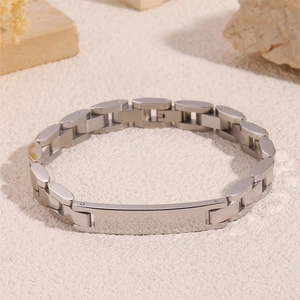 Gros plan d'un bracelet d'identité en acier titane mat avec maillons plats sur pierre